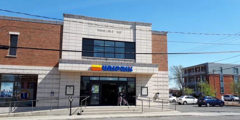 Porte sur la rue Saint-Jean, il y a un stationnement réservé à côté droit du bâtiment. 